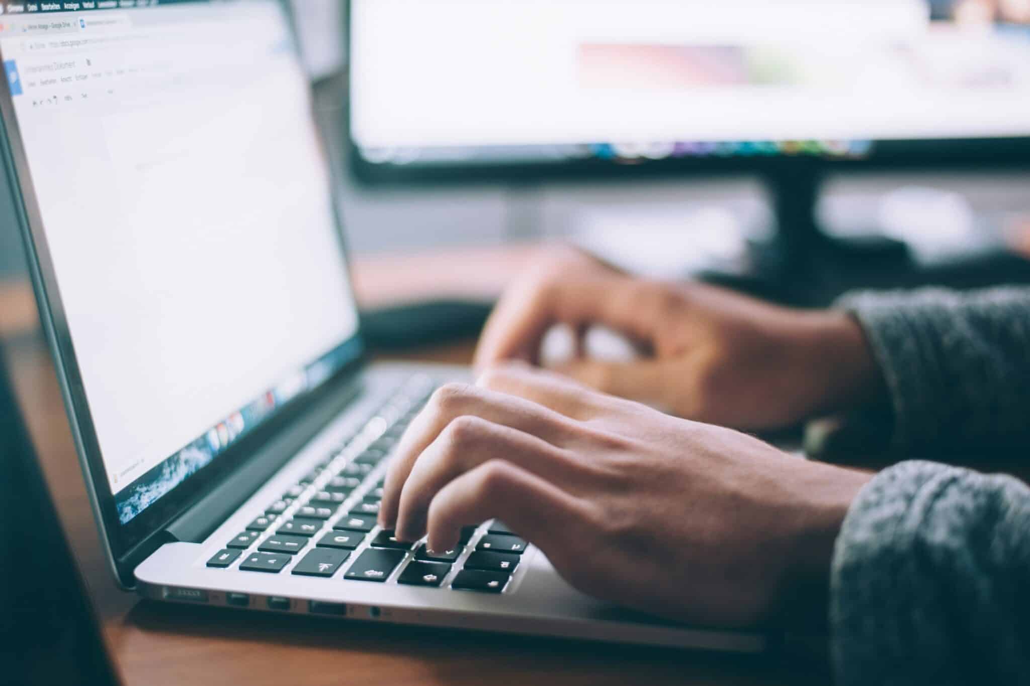 An image of a person typing on a laptop.