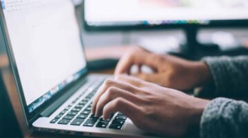 An image of a person typing on a laptop.